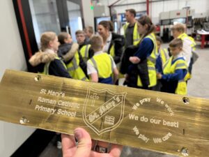 WHAT MORE PRESENTED ST MARYS RC PRIMARY SCHOOL WITH A BESPOKE ENGRAVED PLAQUE DURING THEIR VISIT